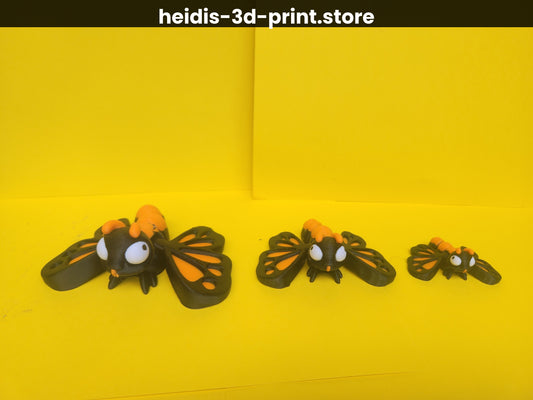 Three 3D printed cute butterfly figures in small, medium, and large sizes lined up on yellow background, monarch orange and brown colouring, Heidi's 3D Prints New Zealand