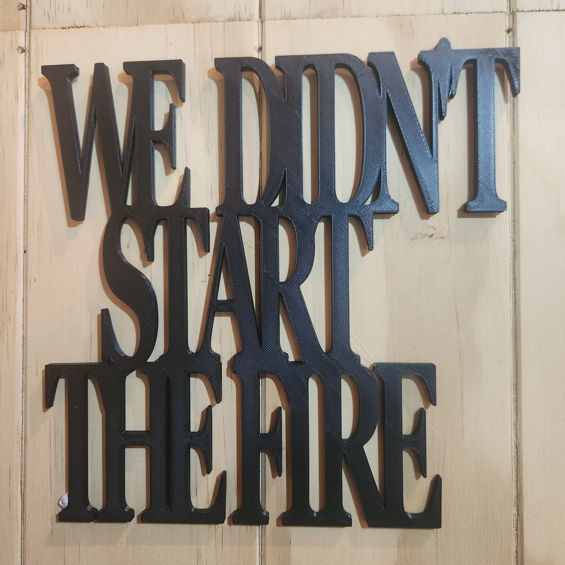 We Didn't Start the Fire 3D printed wall art sign in black, mounted on whitewashed wood wall, showing bold chunky serif lettering