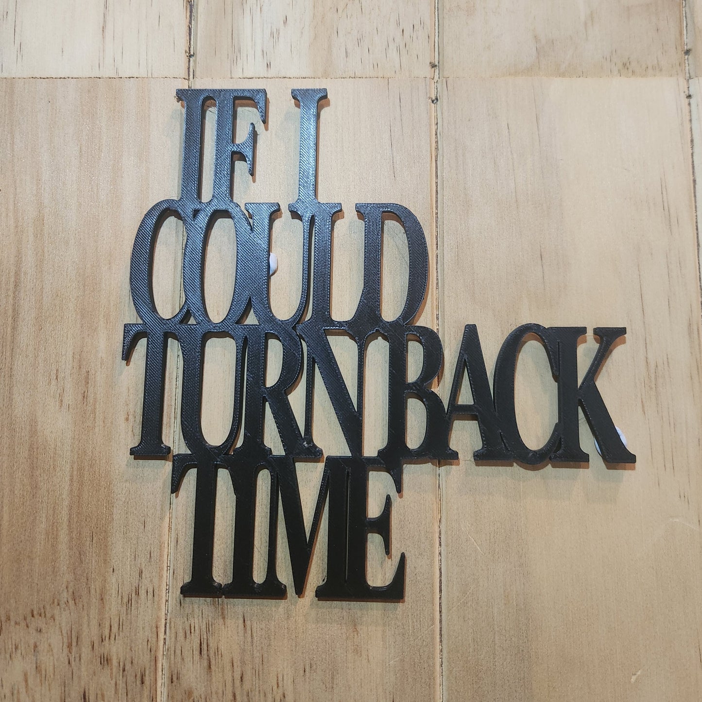 If I Could Turn Back Time wall art sign mounted on a whitewashed wooden wall, showing the chunky stacked serif lettering in black
