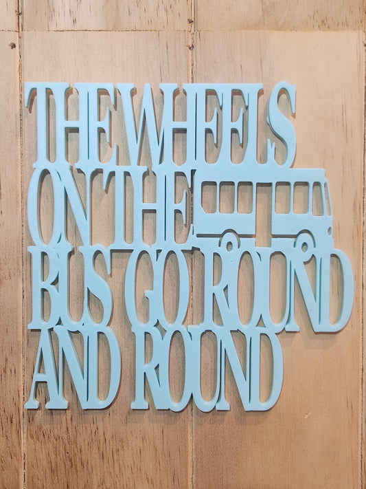 3D printed sky blue PLA wall art sign reading The Wheels on the Bus Go Round and Round with bus silhouette, mounted on a wood wall, 190mm x 190mm, handmade in Upper Hutt New Zealand