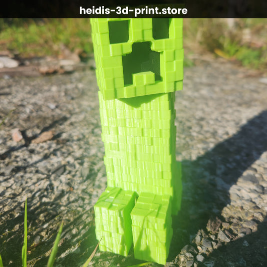 Large 3D printed Minecraft Creeper figure in bright green PLA, standing on gravel in sunlight, 48mm wide × 70mm long × 150mm tall, handmade in Upper Hutt New Zealand by Heidi's 3D Prints