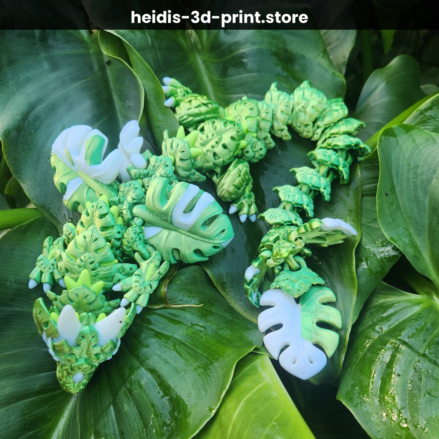 Full body of 3D printed Monstera Leaf Dragon, 47cm articulated figure in green and white PLA, coiled across tropical leaves, handmade in Upper Hutt New Zealand